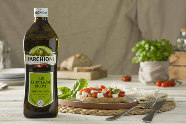 Bottle of Extra Virgin Olive Oil on table with Italian Dishes
